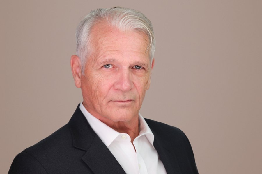 Actor headshot on a warm neutral background