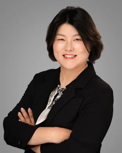 Conference headshot of a woman in a black blazer and patterned scarf