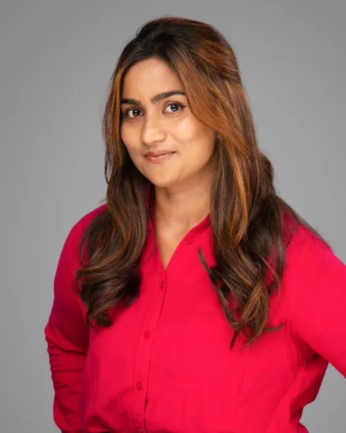 Conference headshot of a woman in a red shirt with long wavy hair