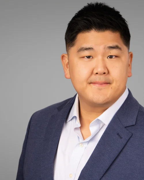 On-site headshot of Andy Yoo photographed on a grey backdrop at his workplace