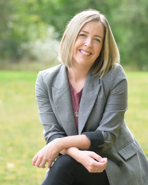 Outdoor personal branding portrait of a consultant in a grey blazer