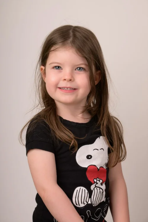 A girl in a black graphic tee with her shoulder turned