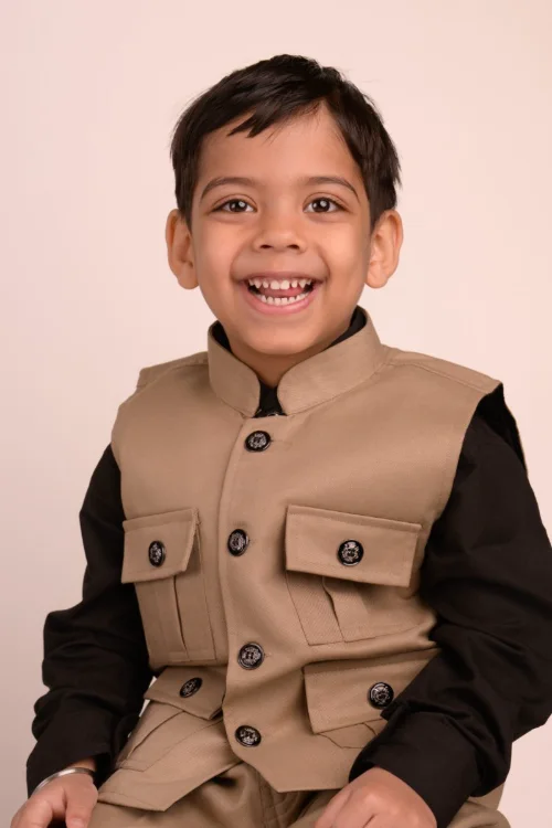 A boy in a tan waistcoat laughing
