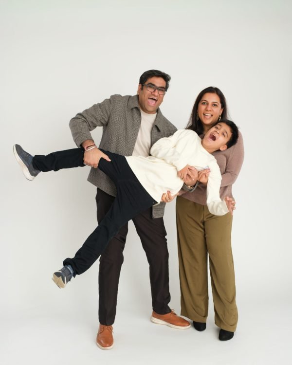 Parents lifting their laughing child during a playful studio family session in Langley
