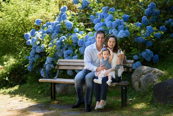 Family seated together on a fallen log in a Fraser Valley forest during a Langley family session