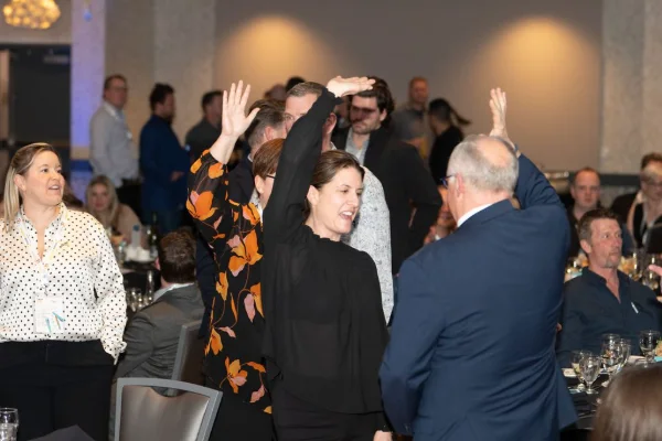 Guests raising their hands to bid during the live auction at a charity gala