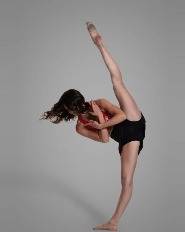Contemporary dancer holding an extended line on a grey studio backdrop