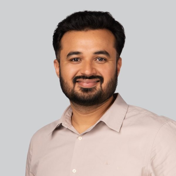 Career expo headshot of a man in a beige shirt on a grey backdrop