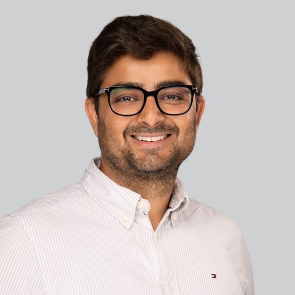 Conference headshot of a bearded man in glasses and a striped shirt