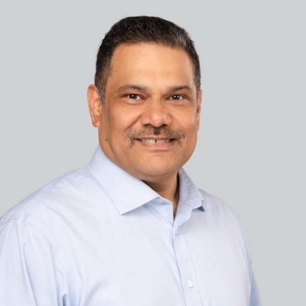 Conference headshot of a man in a light blue dress shirt photographed at a headshot booth