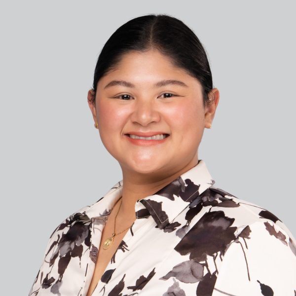 Conference headshot of a smiling woman in a black and white floral blouse