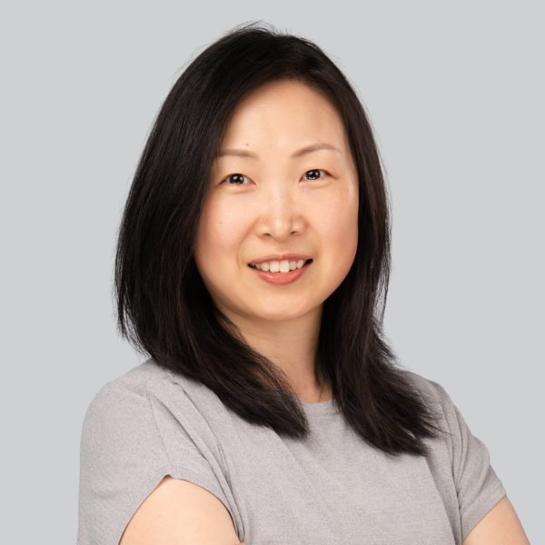 Conference headshot of a woman in a grey top with arms crossed