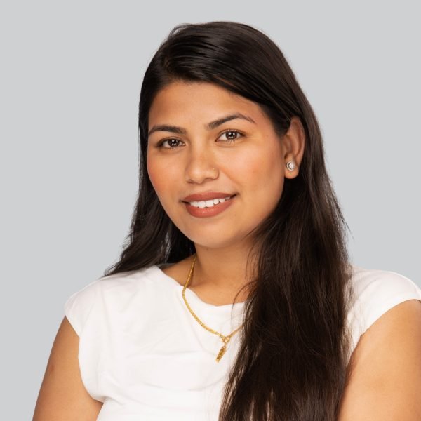 Conference headshot of a woman in a white top with a gold necklace