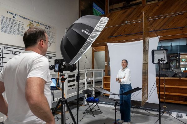 Conference attendee posing on a white backdrop inside the headshot booth
