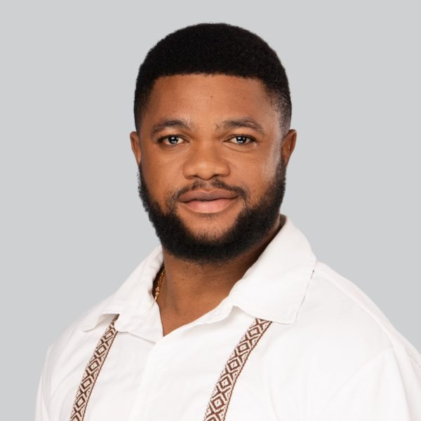 Event headshot booth portrait of a smiling man in a white shirt on a grey studio backdrop