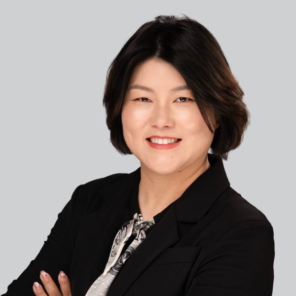 Event headshot booth portrait of a woman in a black blazer with arms crossed