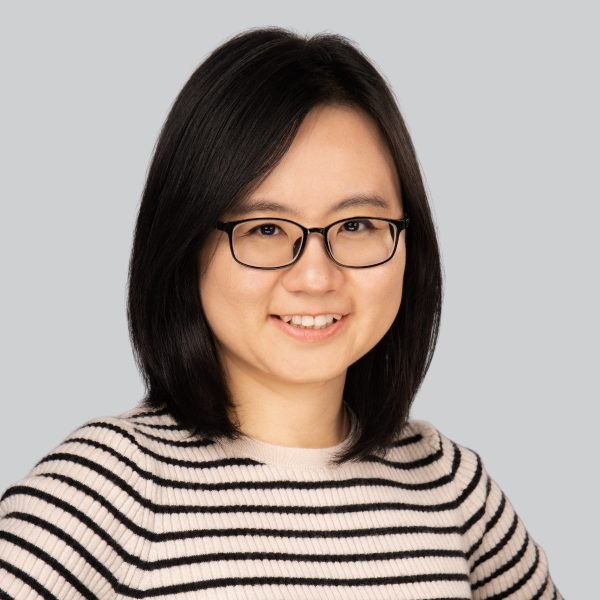 Event headshot of a woman in glasses and a striped knit sweater