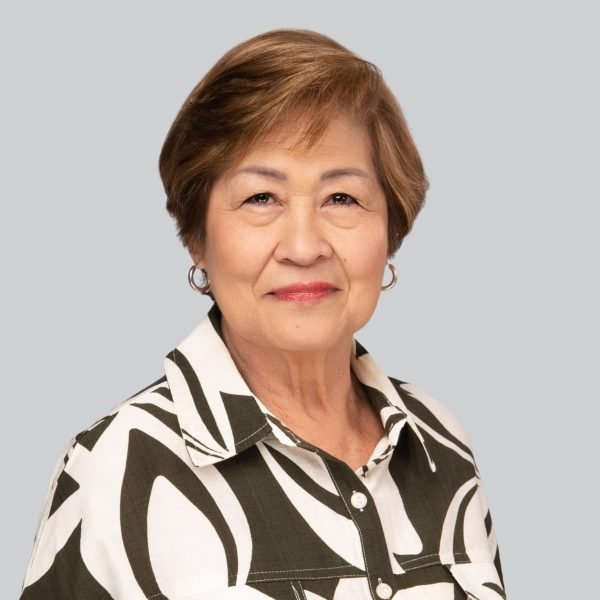 Event headshot of an older woman in a black and white patterned blouse