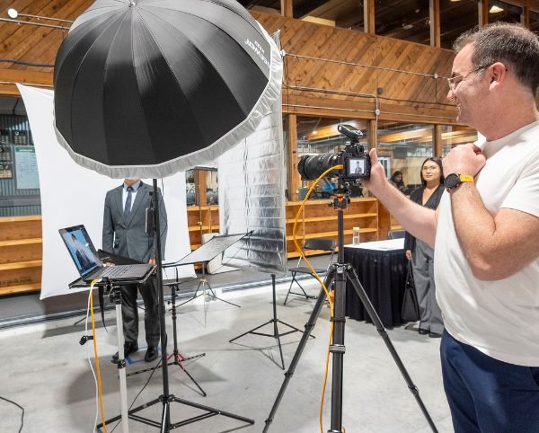 Photographer working the camera at a conference headshot booth in the Lower Mainland