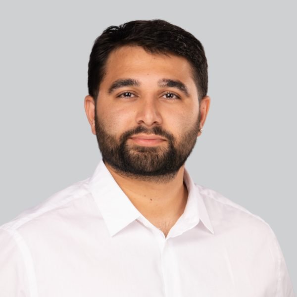 Trade show headshot of a bearded man in a white shirt at an event booth