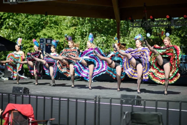 Cultural dance troupe performing in costume on an outdoor festival stage