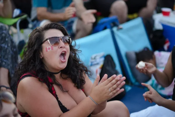 Festival-goer clapping and cheering from the crowd during a performance