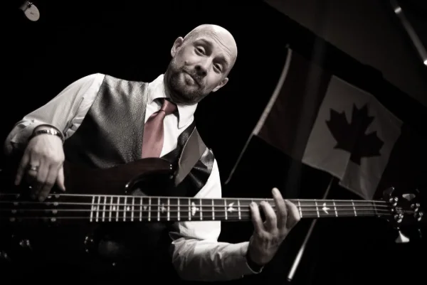 Black and white photograph of a bassist performing at a live music event