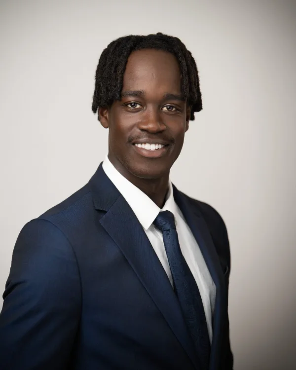 Lawyer headshot of Richard Mageto in a navy suit and tie