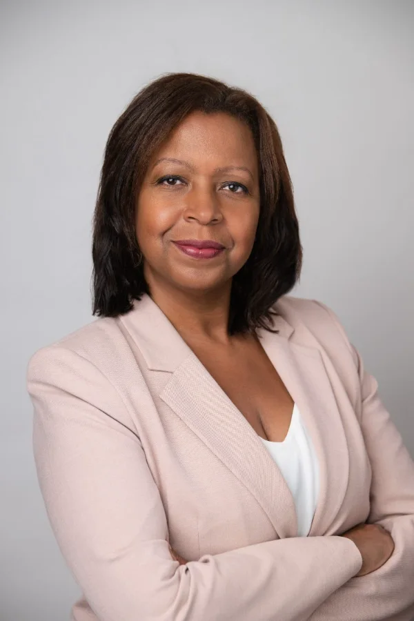 Lawyer headshot of a woman in a pink blazer photographed in the studio