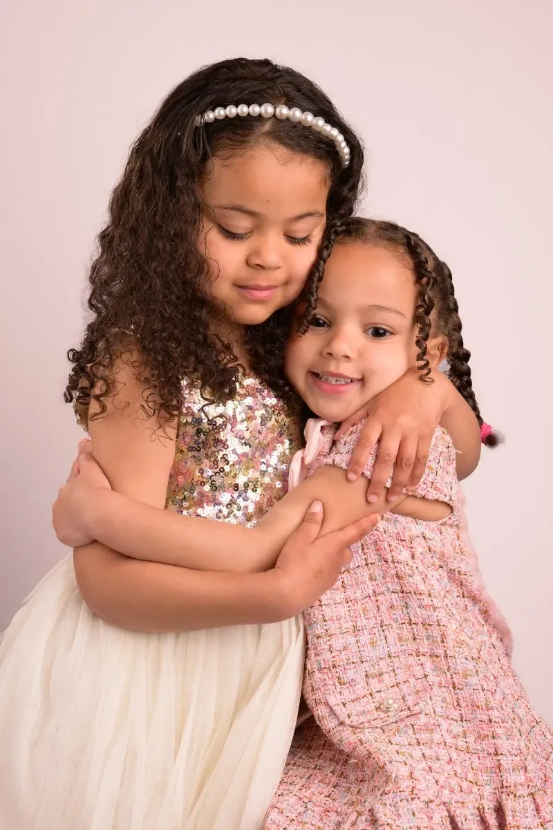 The same two sisters hugging with their eyes closed
