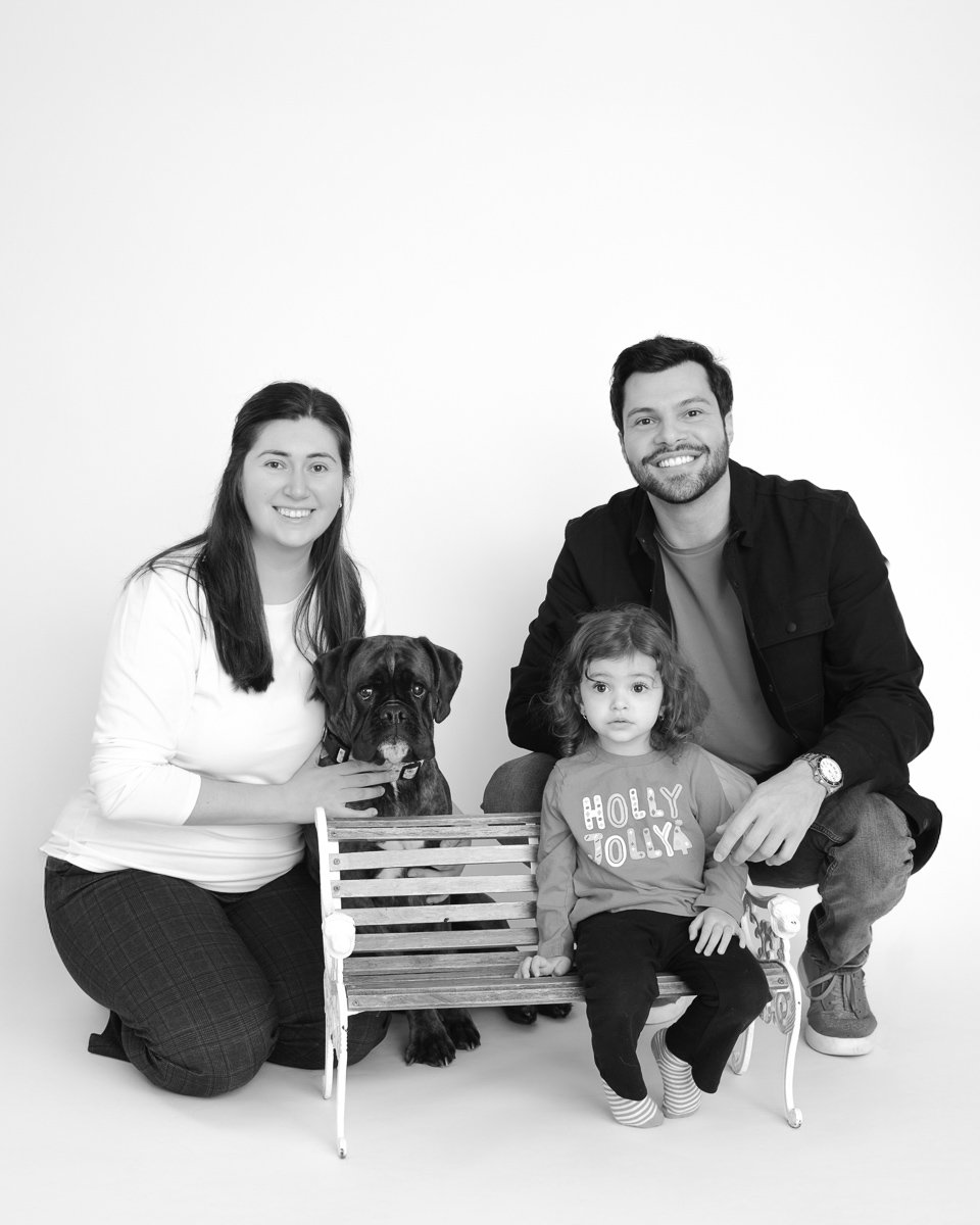 Family with their dog on a bench in black and white during a studio mini session