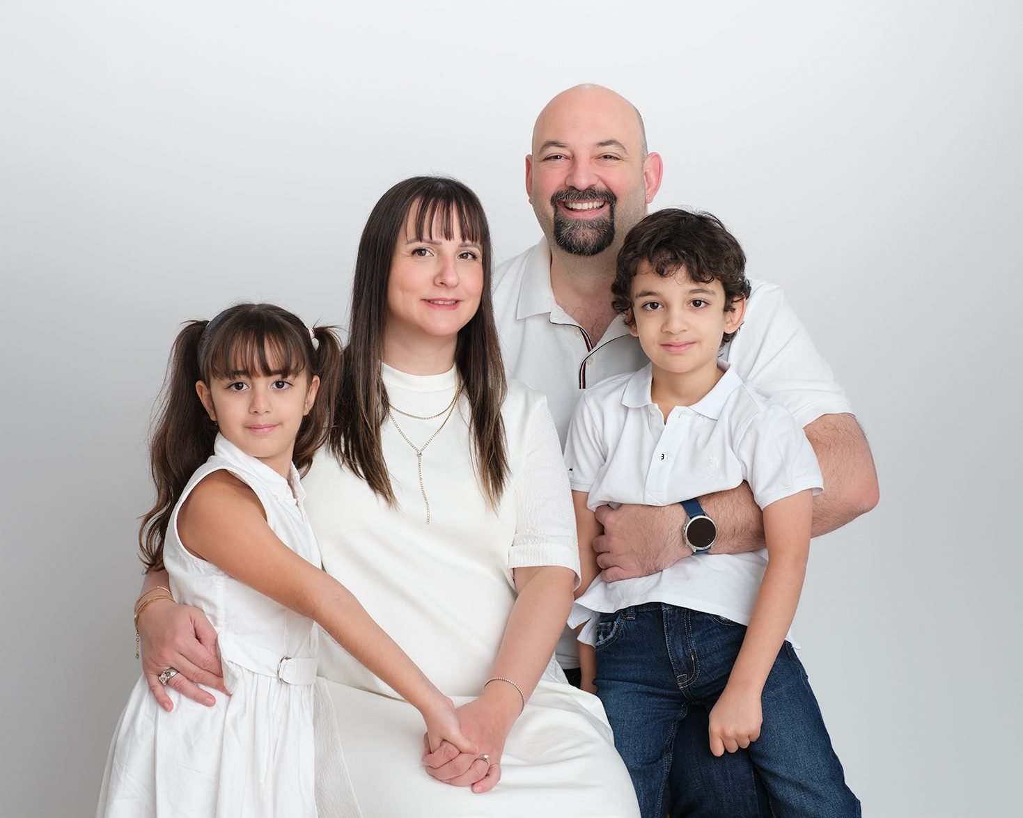 Three generations photographed together on a dark studio backdrop in Langley