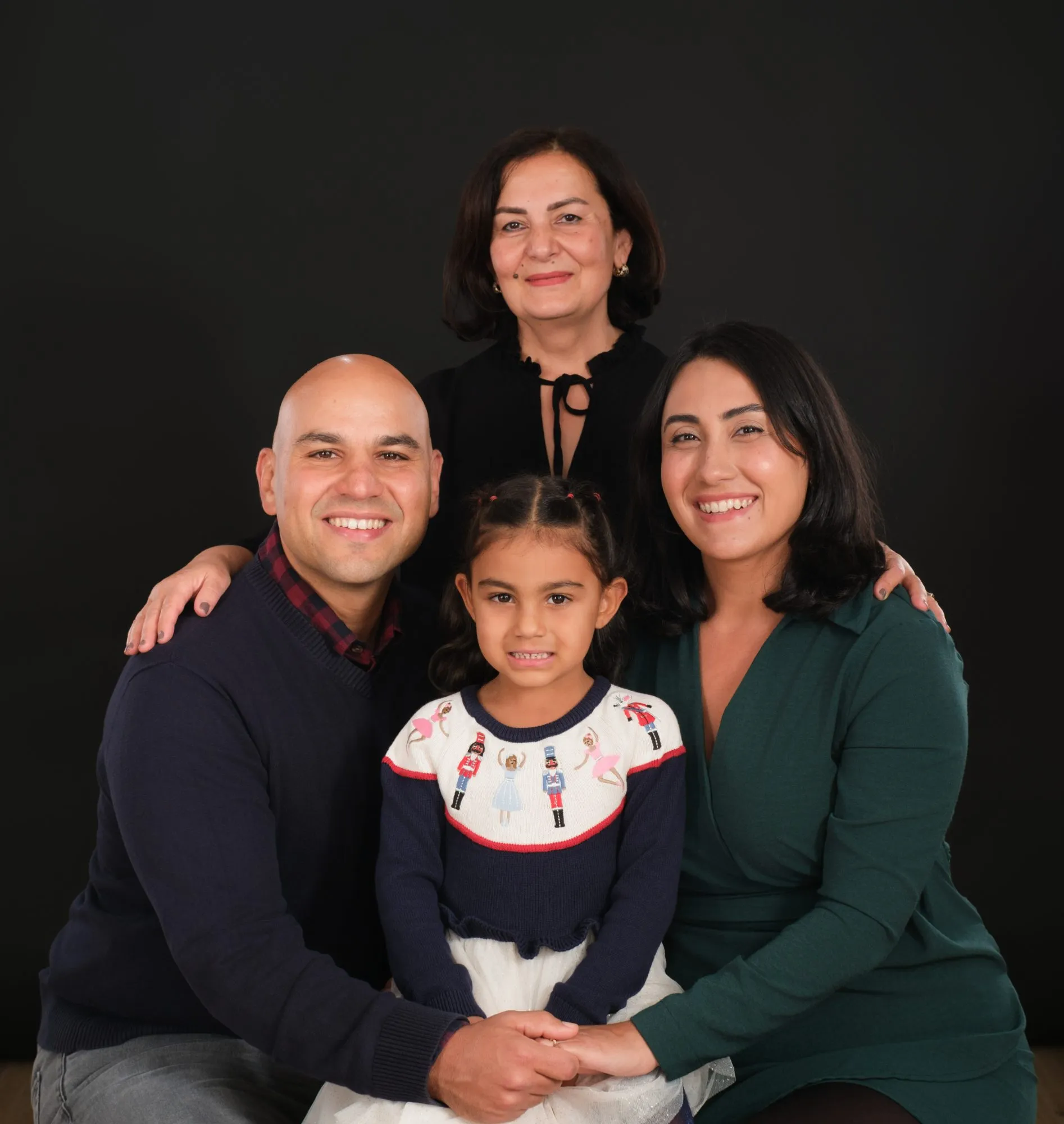 Family of four in white on a bright studio backdrop