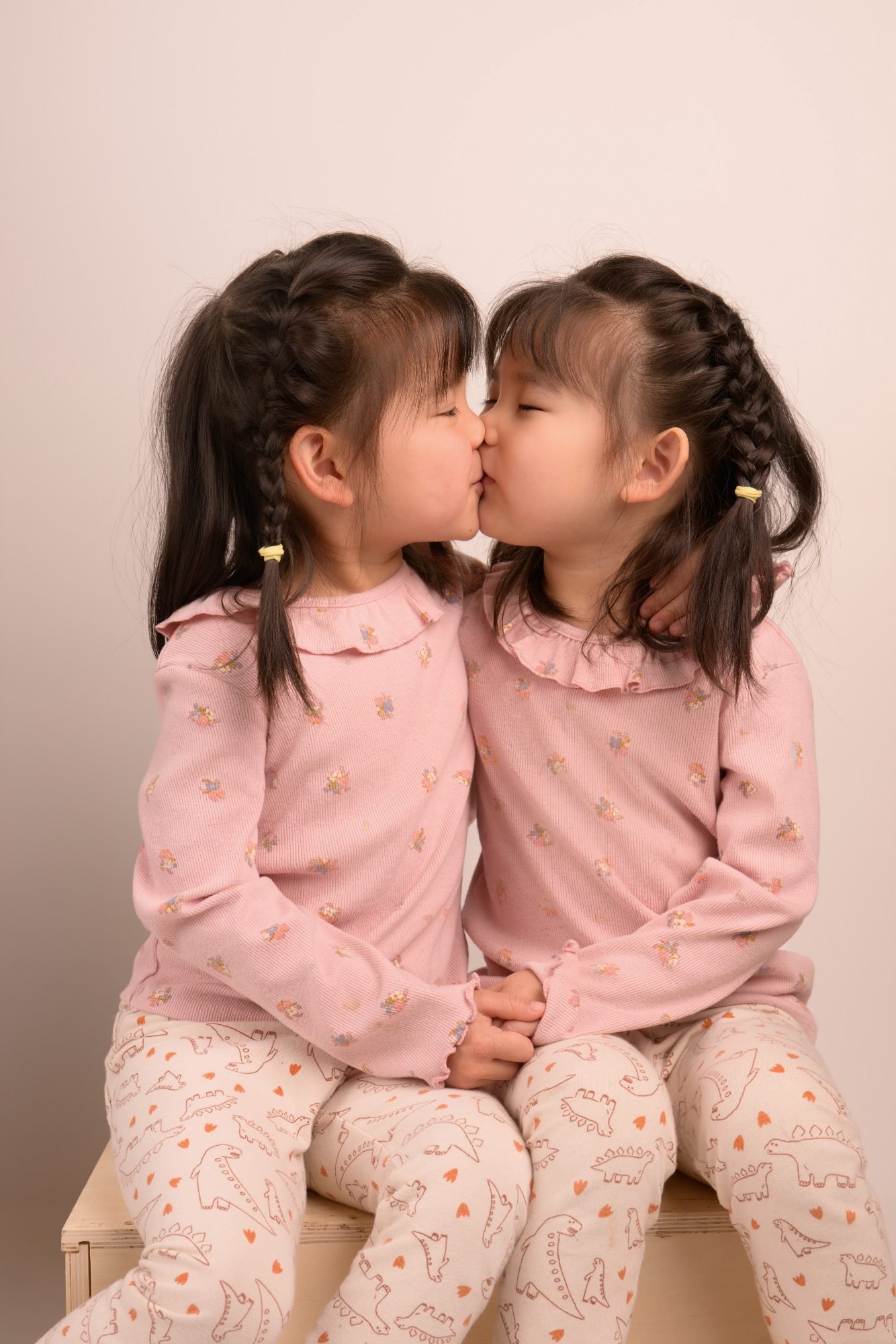 Two sisters leaning in nose to nose during their sibling portrait