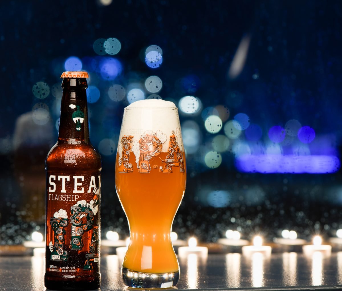 Craft beer photography of a bottle and full glass with candlelight bokeh behind