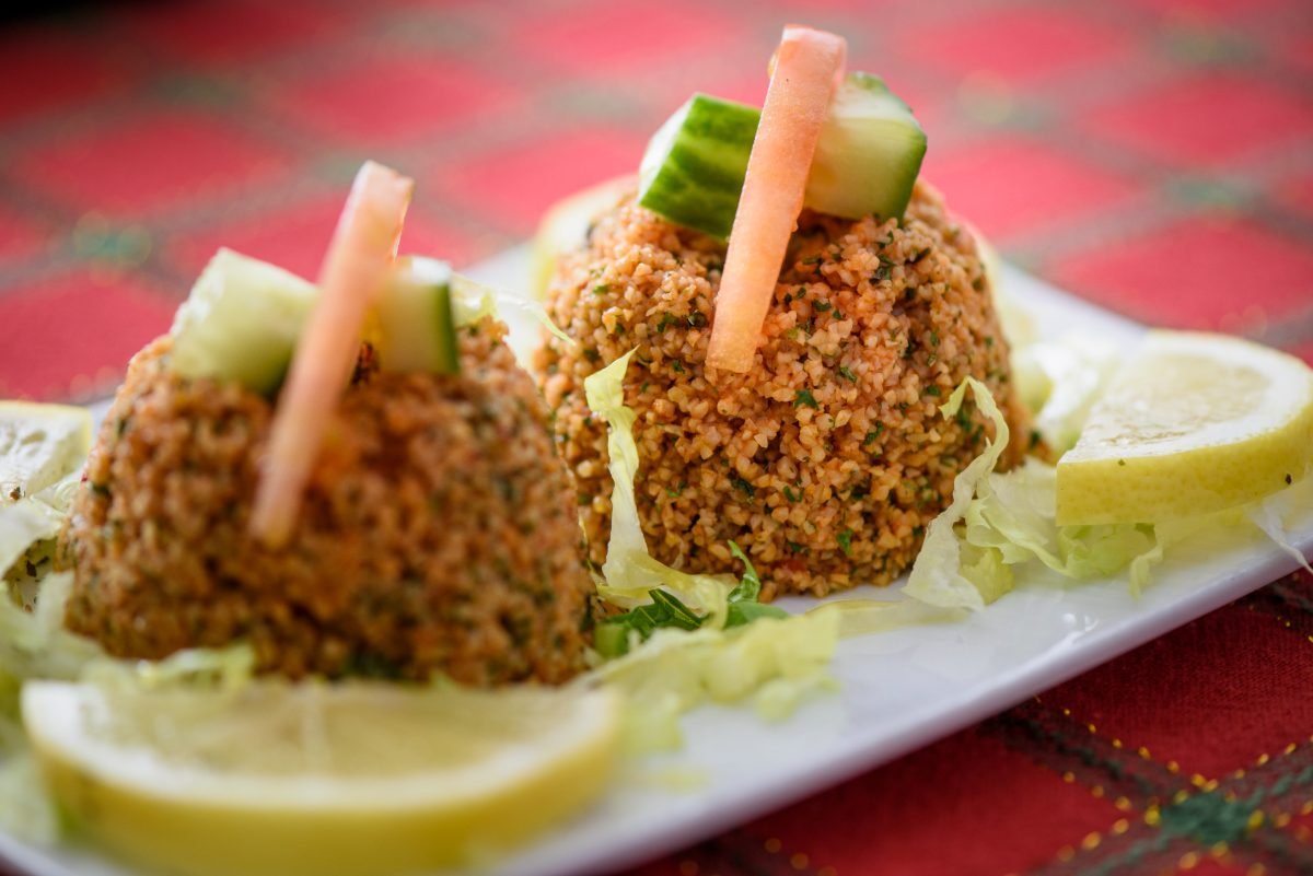 Mediterranean restaurant food photography of two kisir mezze mounds with lemon and cucumber