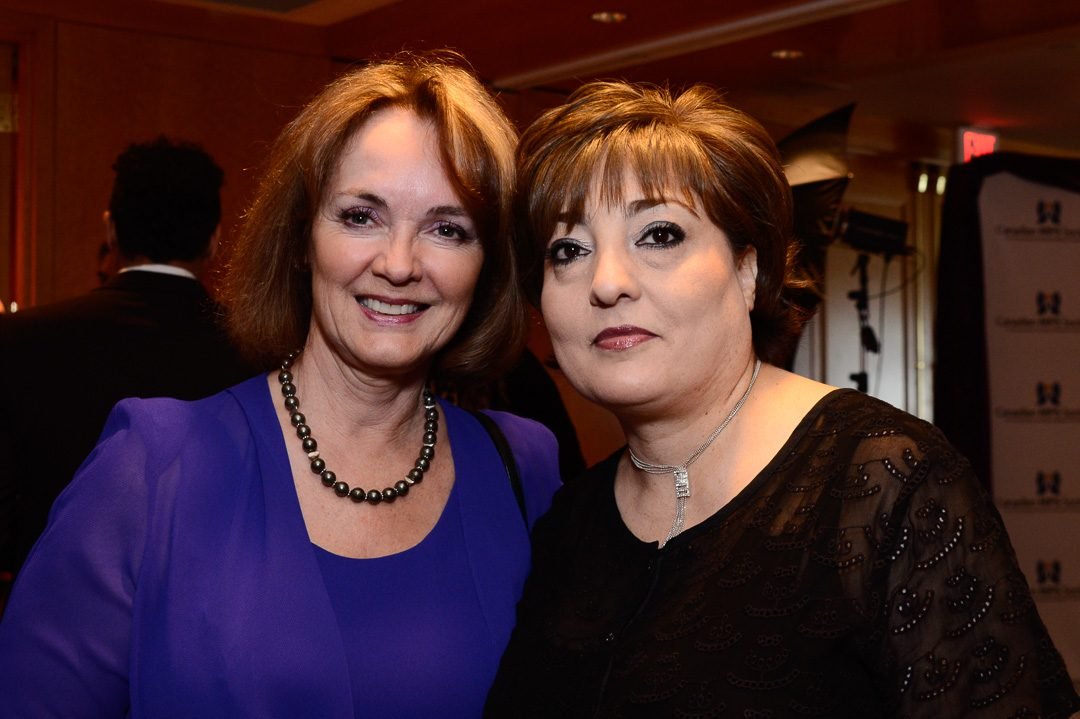 Two guests photographed together in the ballroom at a charity fundraising gala