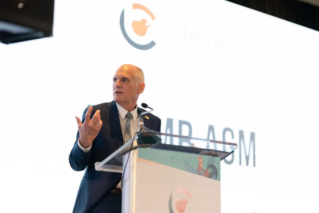 Keynote speaker addressing delegates from a branded podium at a BC industry conference