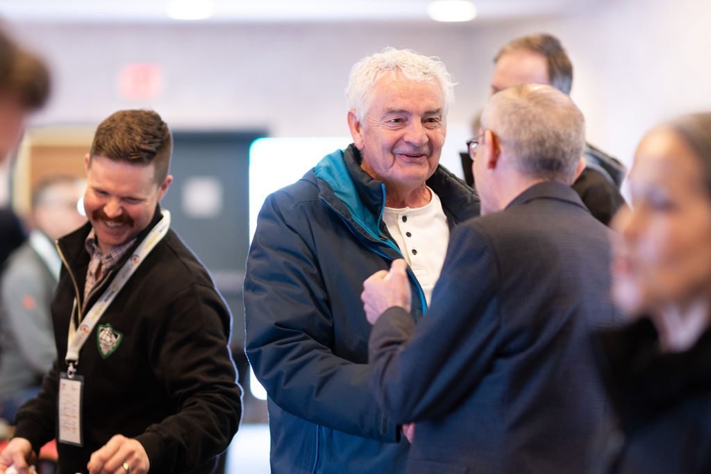 Delegates greeting each other and laughing during a conference networking reception