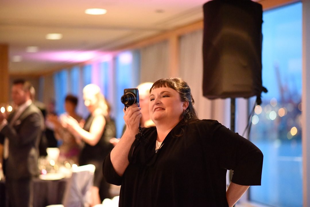 Guest filming the program on her phone during a charity gala dinner in Vancouver