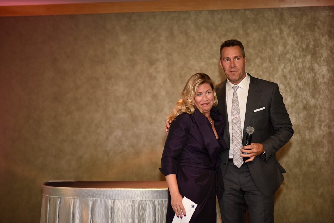 Gala hosts with a microphone between segments of a charity fundraising evening