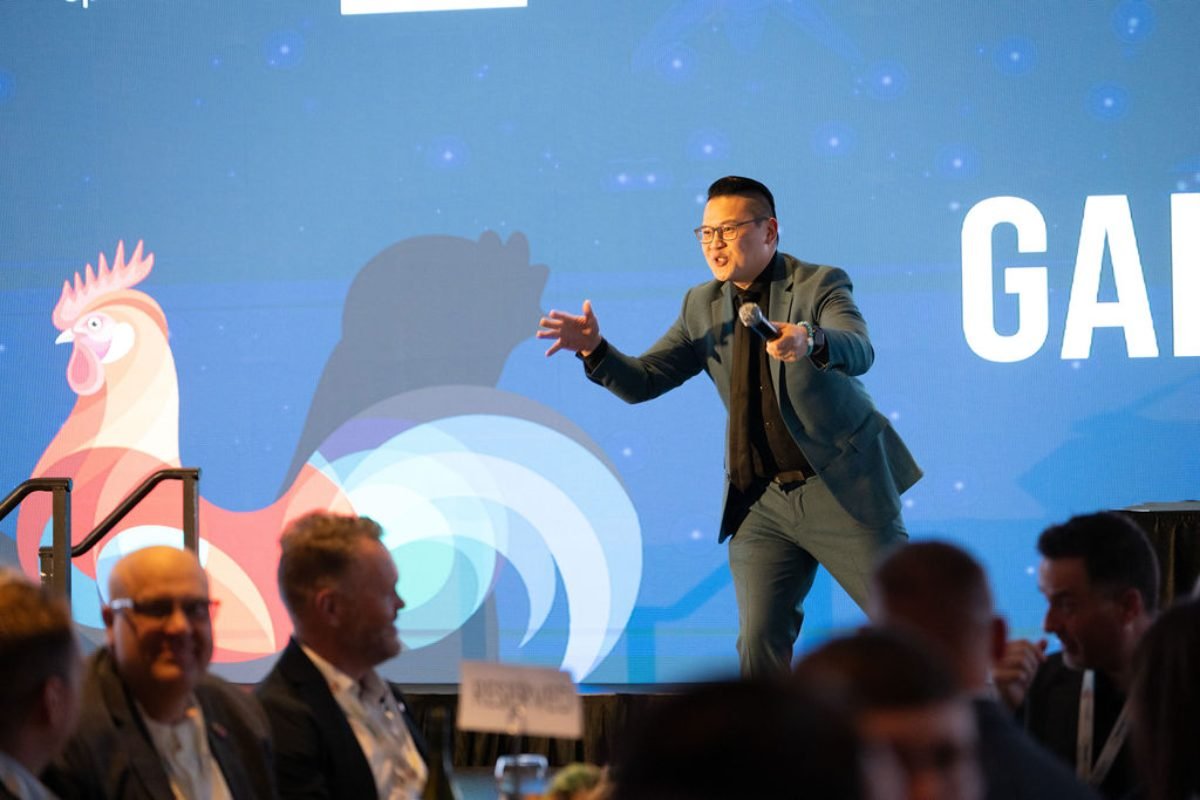 Emcee with a microphone addressing guests during an industry association gala dinner