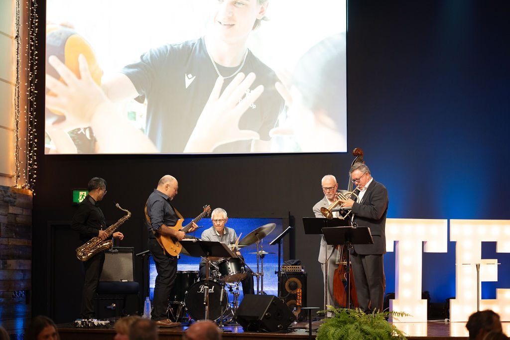 Live band performing on stage during the entertainment set at a corporate charity gala