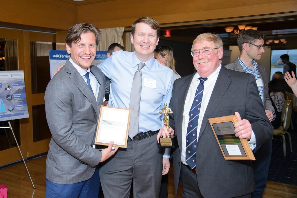 Three award winners holding their plaques and trophy at a BC industry recognition evening