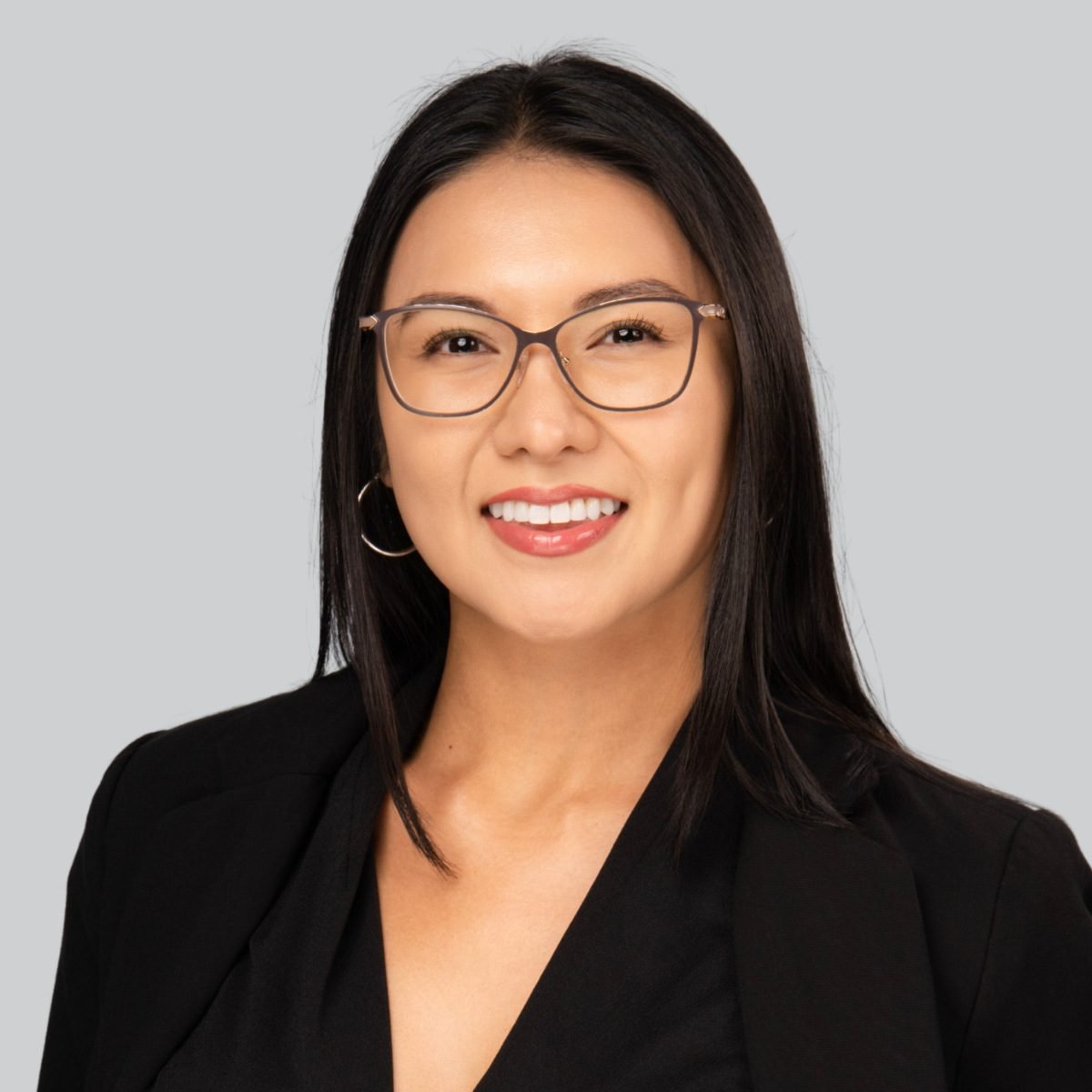 Event headshot booth portrait of a woman with glasses in a black blazer