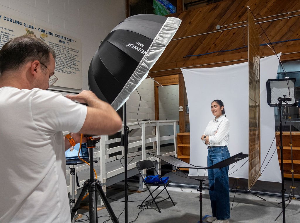 Photographer directing an attendee through a two minute headshot session at an event booth