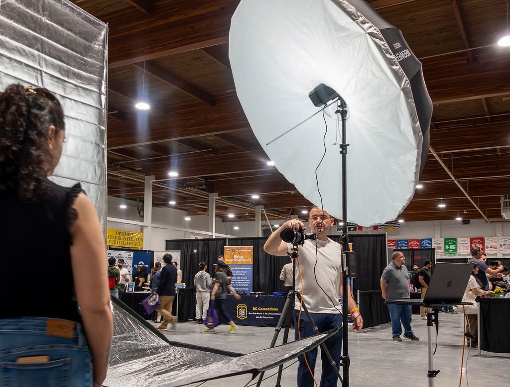 Event headshot booth set up with studio lighting and backdrop on an event floor