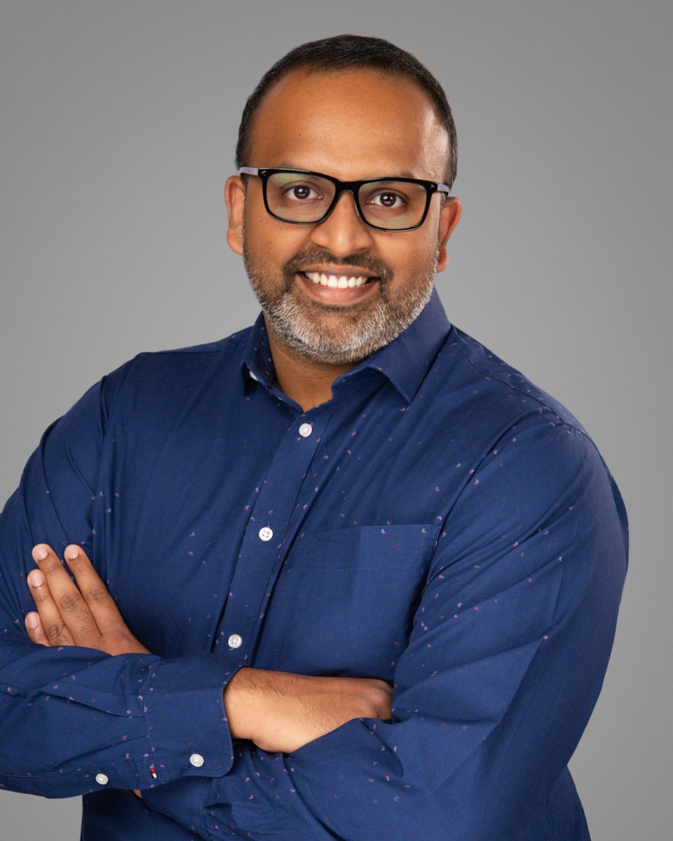 Conference headshot of a bearded man in glasses and a navy shirt