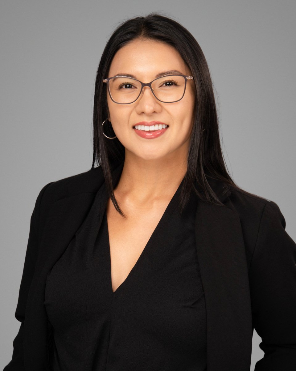 Conference headshot of a woman in glasses and a black blazer