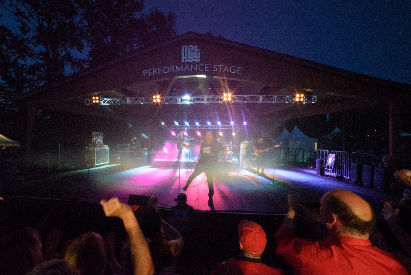 Festival main stage lit in pink and blue as the band plays to a night crowd